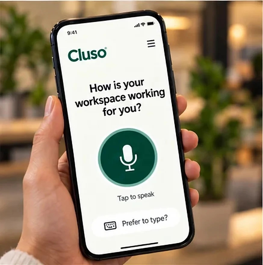 Her phone shows Cluso: "How is your workspace working for you?" and Tap to speak.