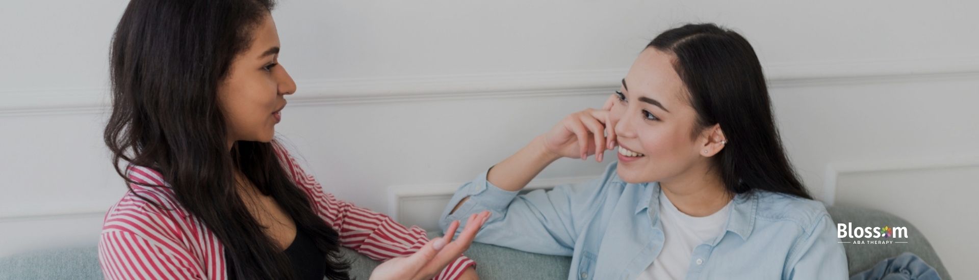 Two women chatting on a couch.