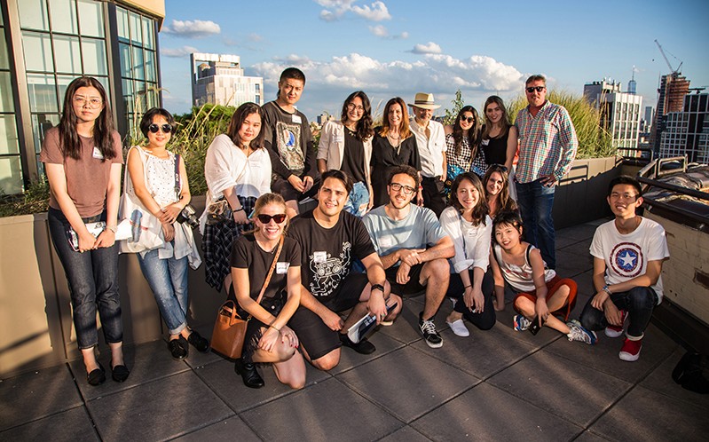 A photo of a group of people in front of a city scape.