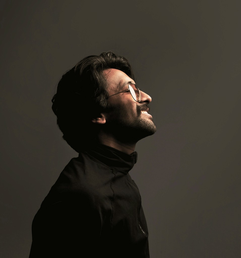 a man with glasses looking up into the sky