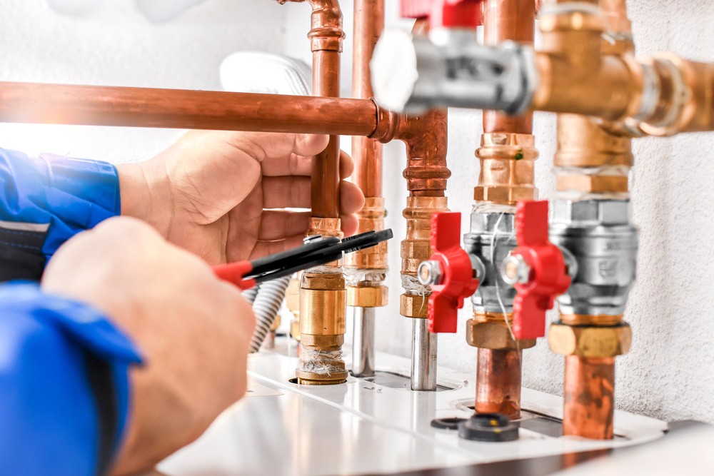 The underside of a boiler, an engineer is removing the boiler 