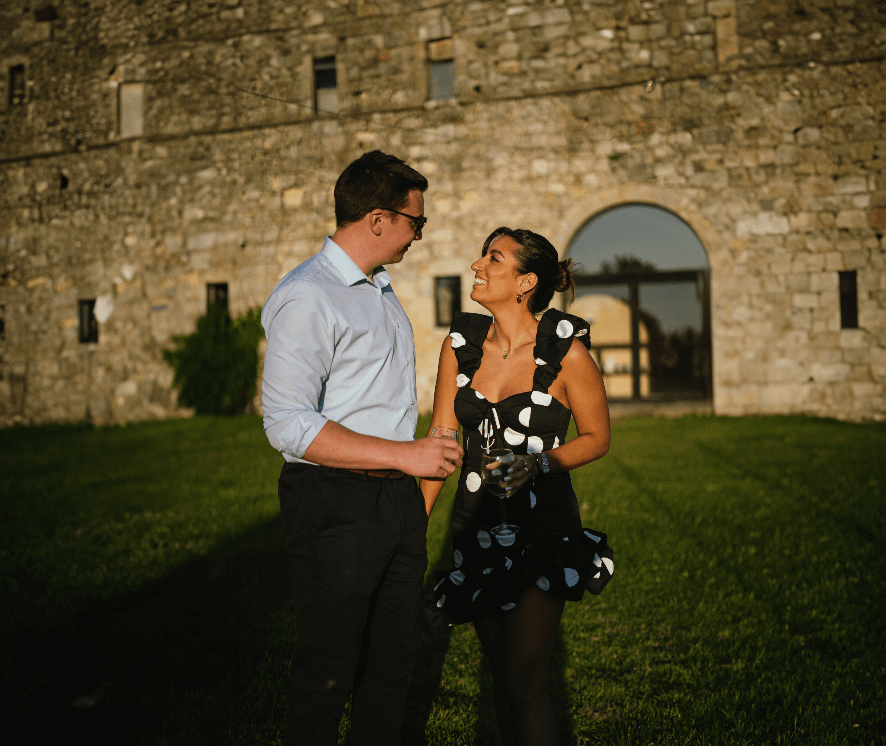 A bride and groom share a kiss, enveloped in the bride's flowing veil. The soft focus and gentle light convey a romantic, intimate atmosphere.