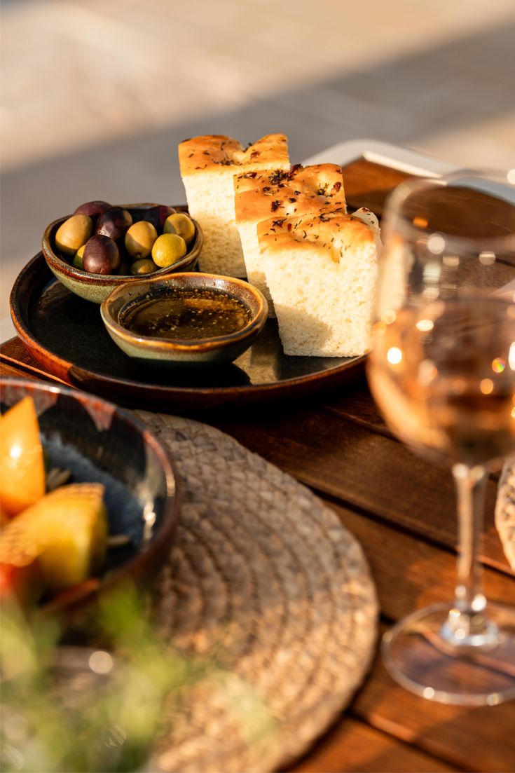 Plated focaccia bread served with olives and herb oil, photographed in warm natural light to reflect Dhoom’s refined presentation style.