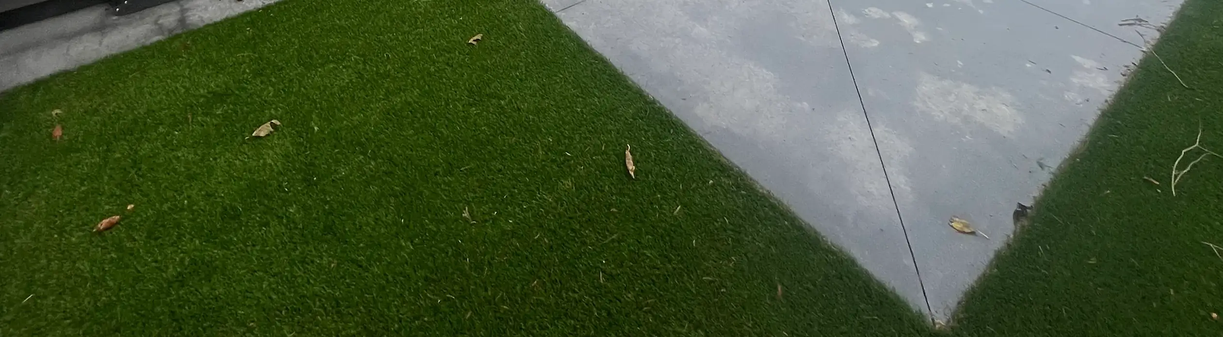 Artificial turf landscaping installed alongside modern concrete patio.