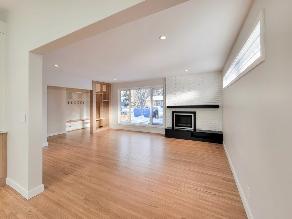 Image of KHD Homes interior design featuring light wood floors, white walls, and modern fireplace setup.