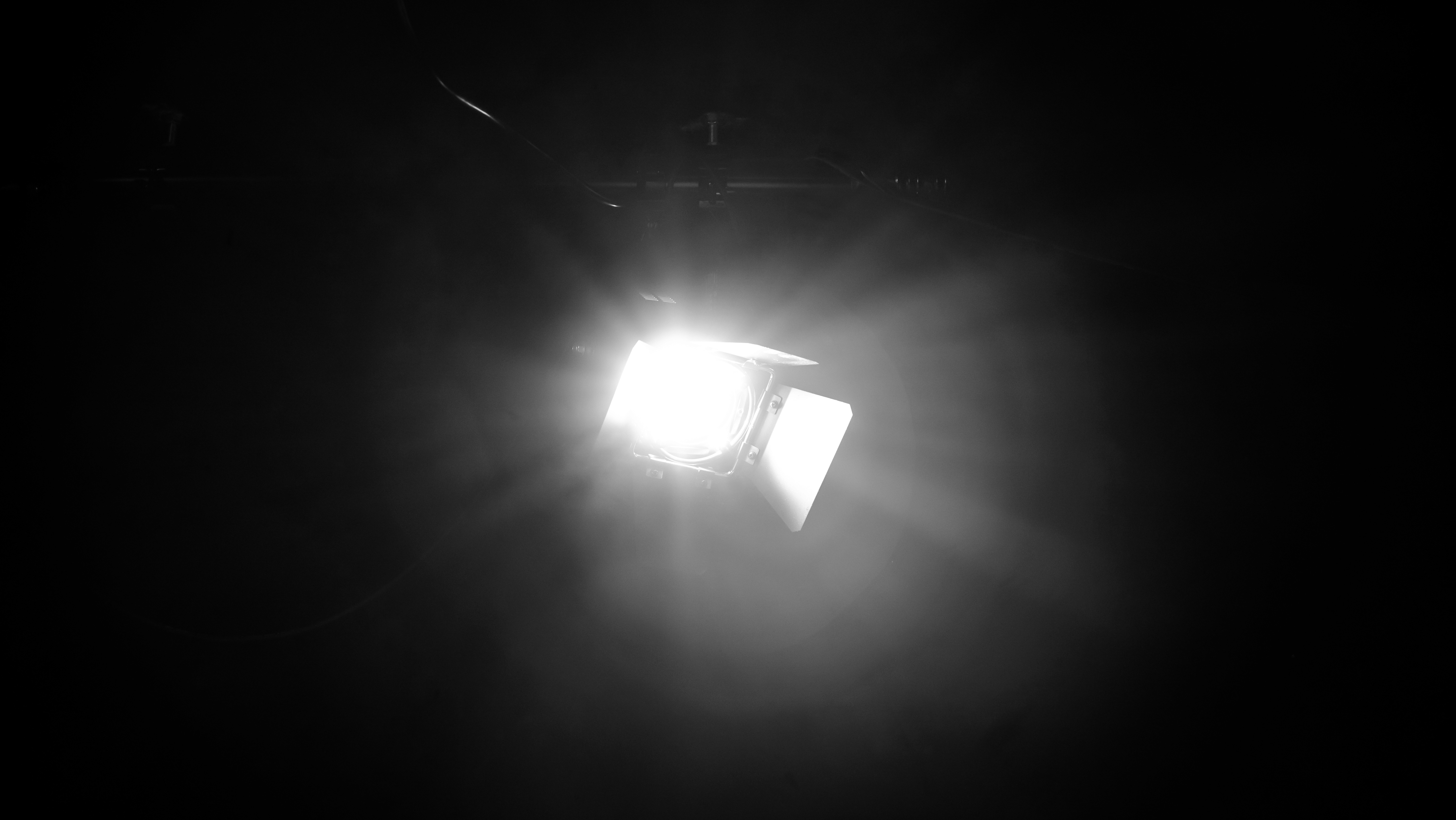 Close-up of a yellow tennis ball sitting on a green court, positioned near the white center line.