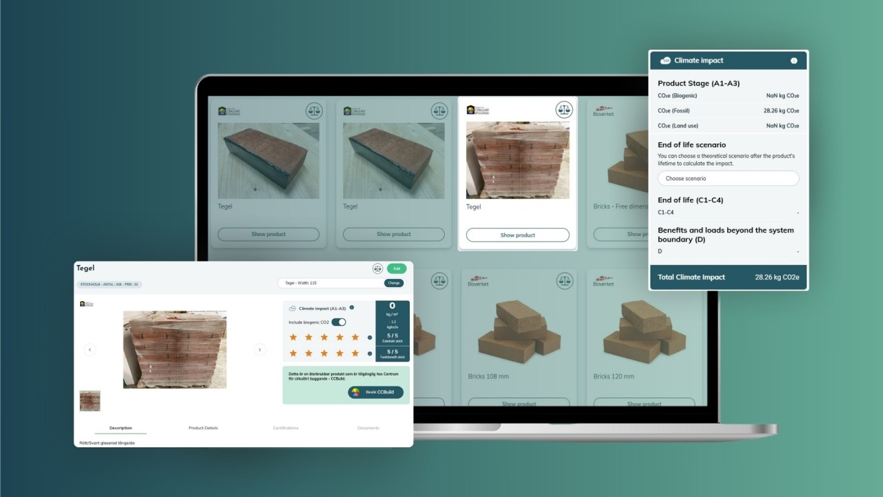 A man stands while two people sit at a table in an office setting, smiling and engaged in conversation. The mood is friendly and collaborative.