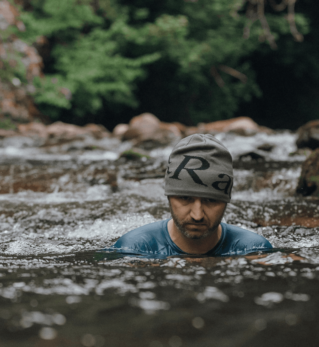 Phil Quirk submerged in a cold lake, participating in a solo cold water dip activity surrounded by a calm, natural landscape.