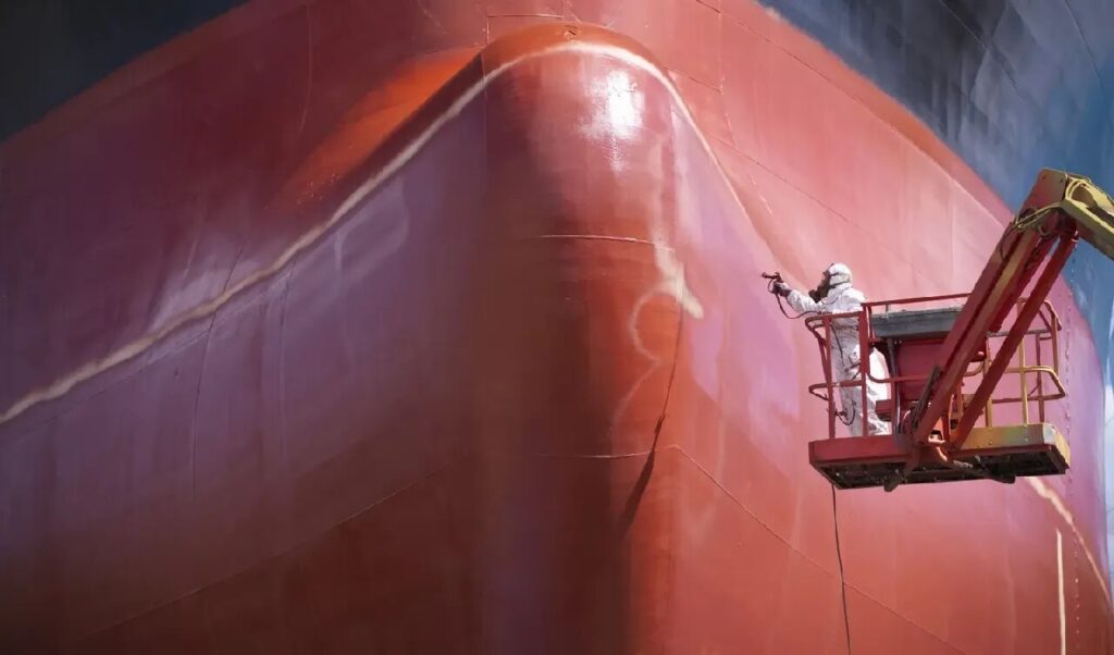 Workers are spraying silicone low surface energy coating on the ship