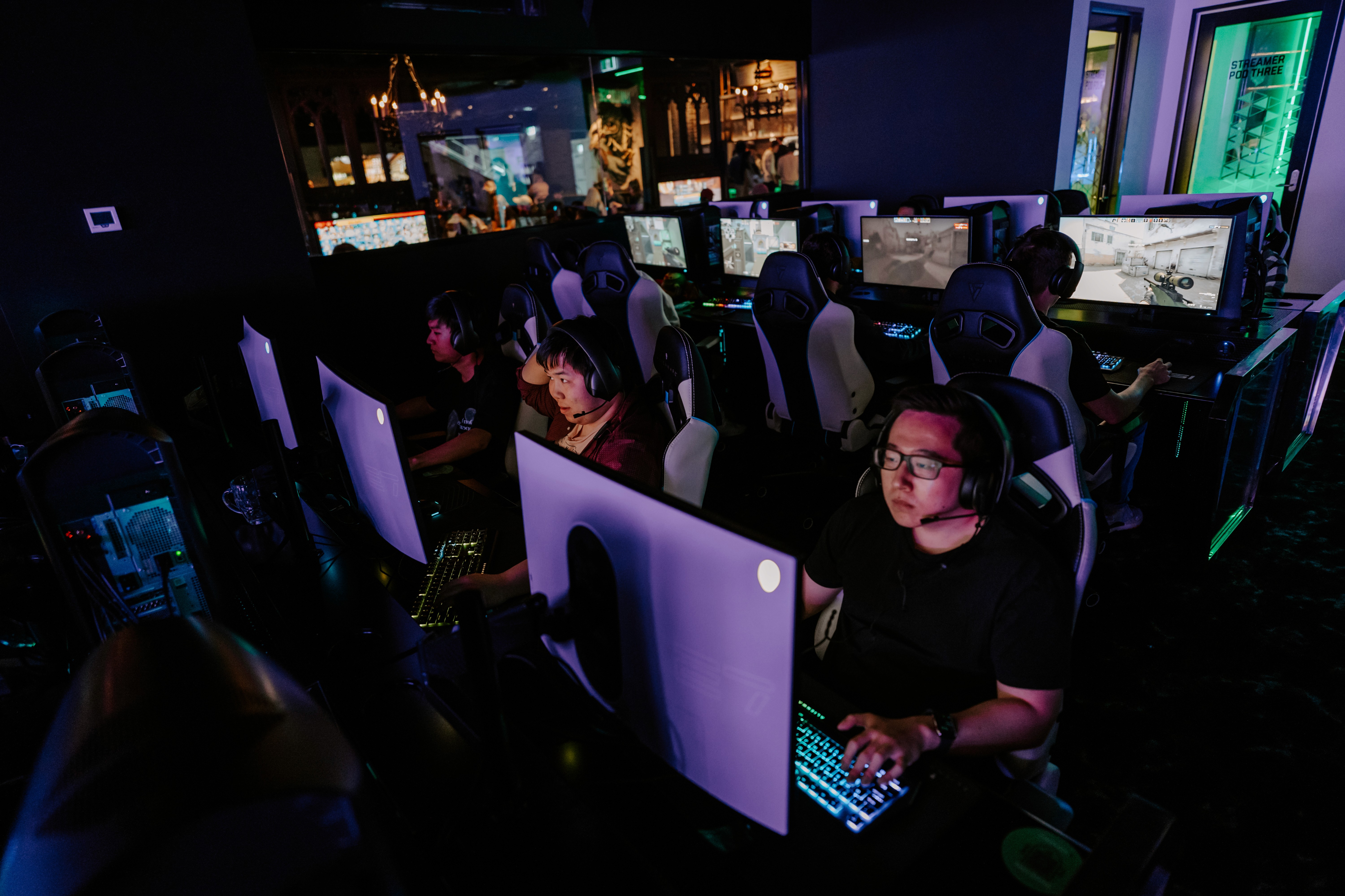 A group of people sitting down towards a stage with computer on them