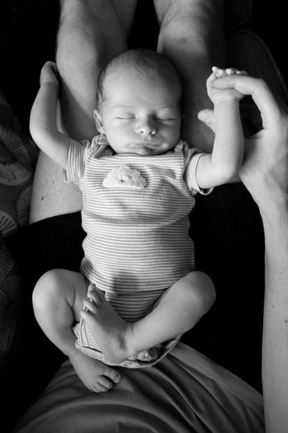 black-and-white-baby-lying-on-parents-legs-katt-jones-photography