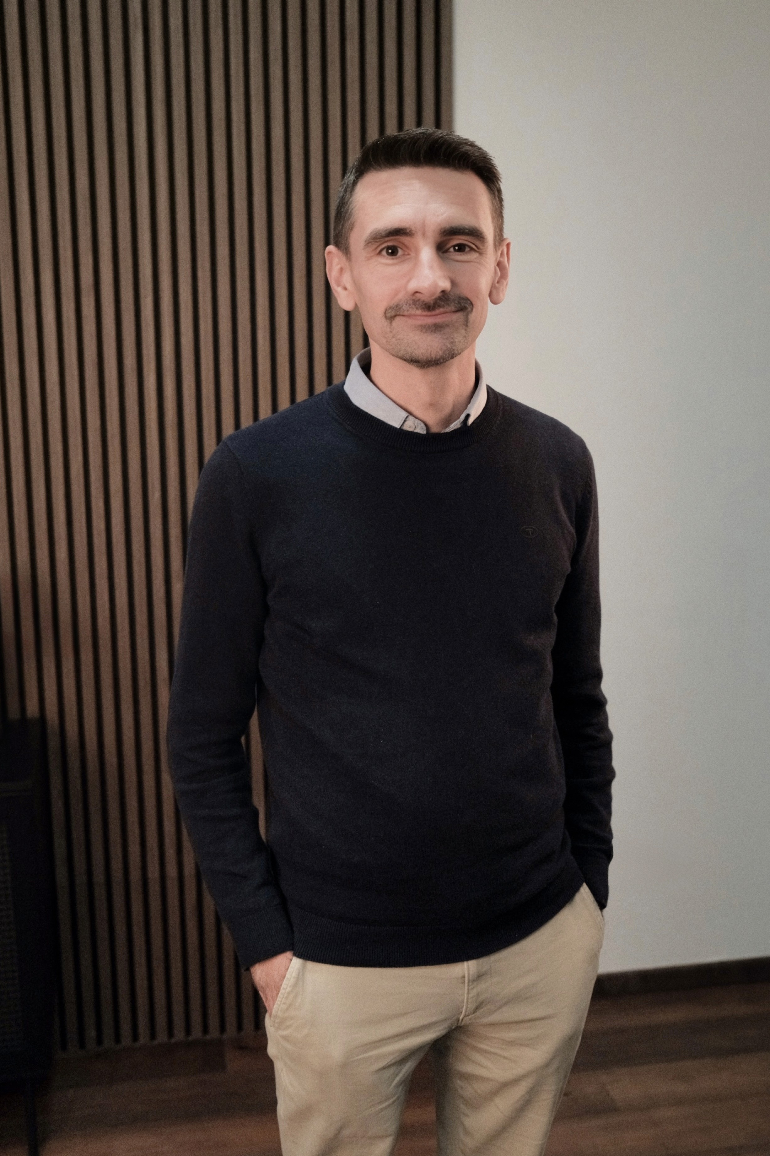 man in black shirt standing beside counter