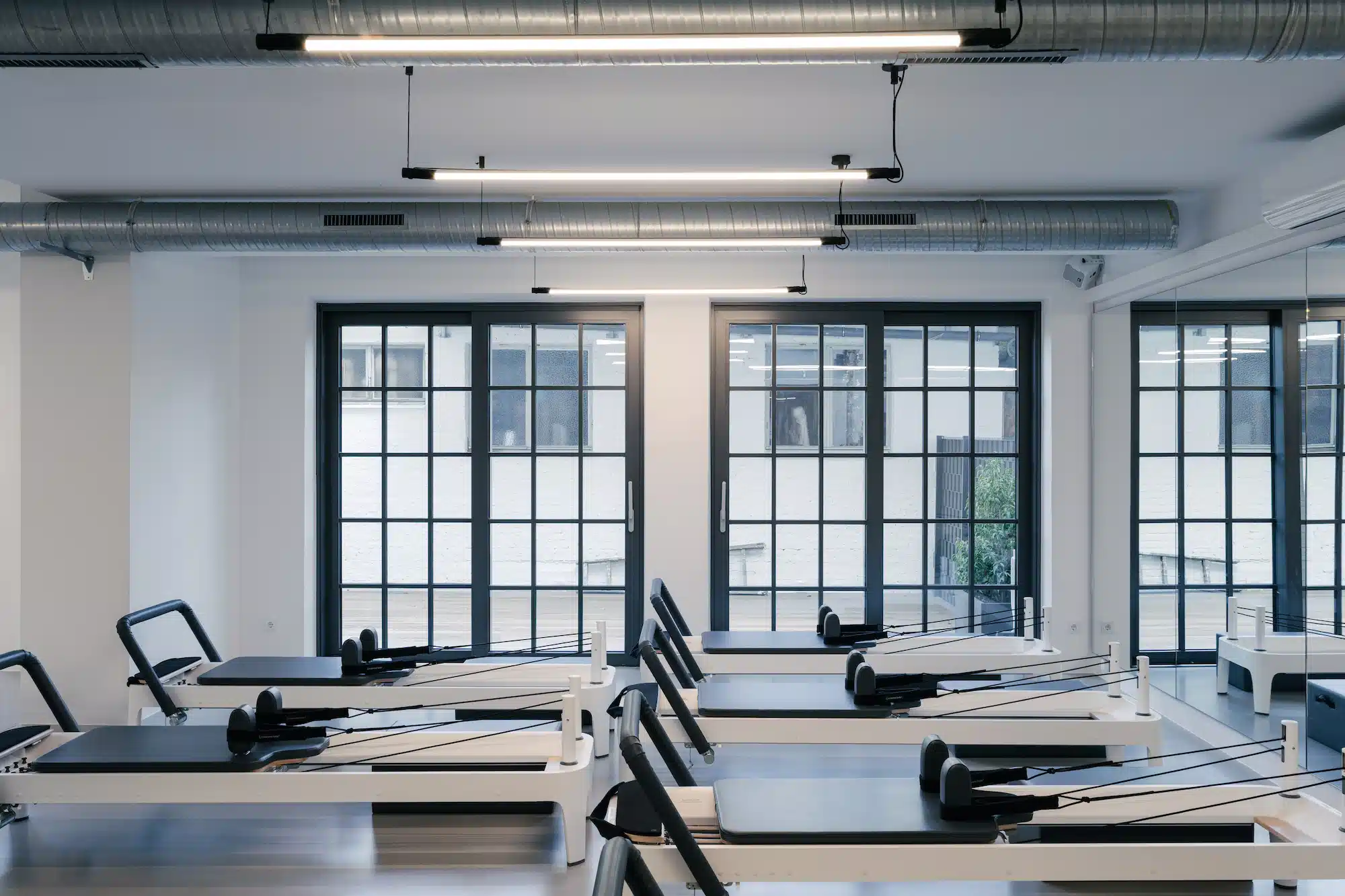Dojo Office – office kitchen with black fitted furniture, exposed brick wall and neon light ceiling