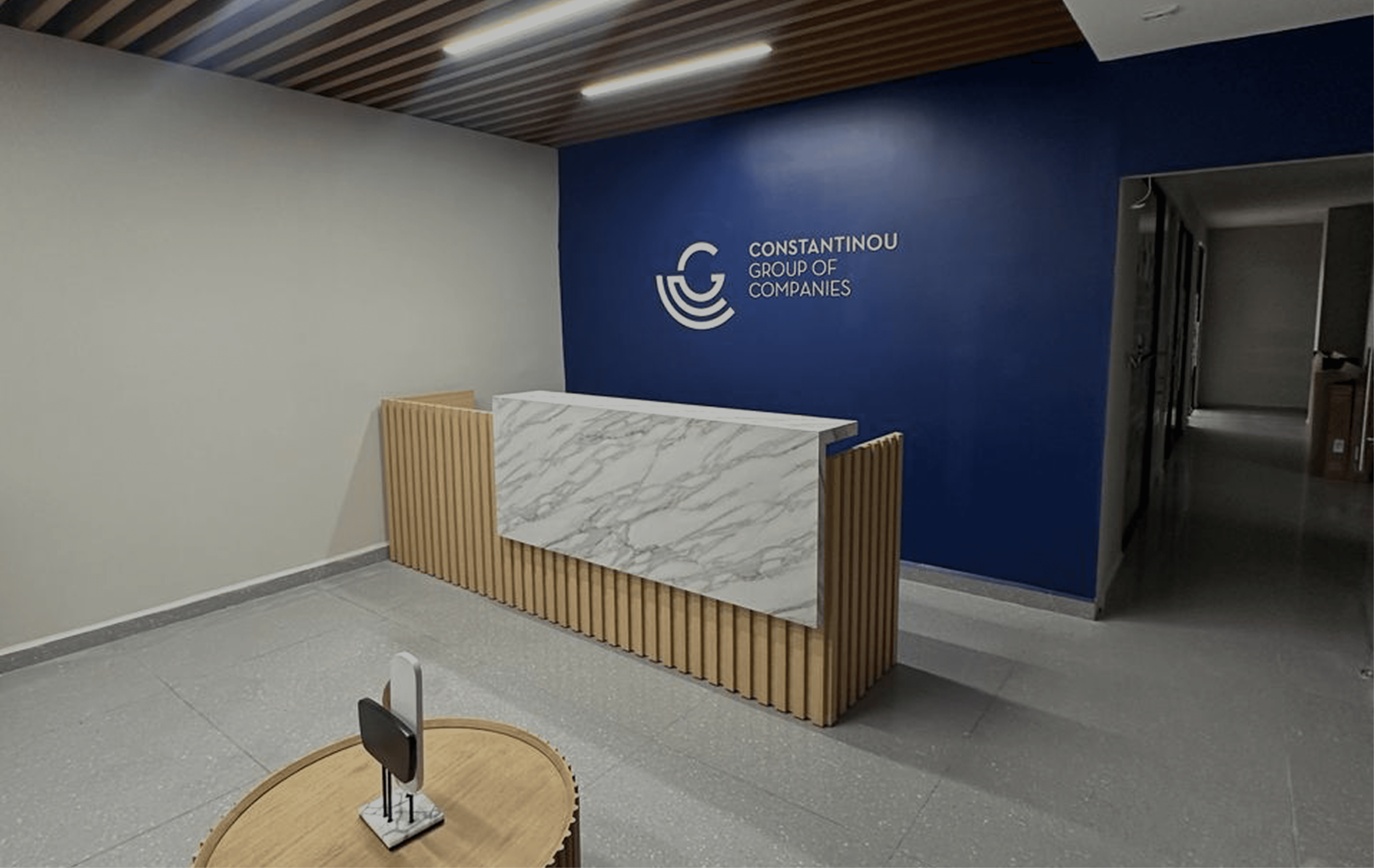 Oficinas del Grupo Constantinou en San José con espacios corporativos abiertos y acabados modernos en vidrio y madera.