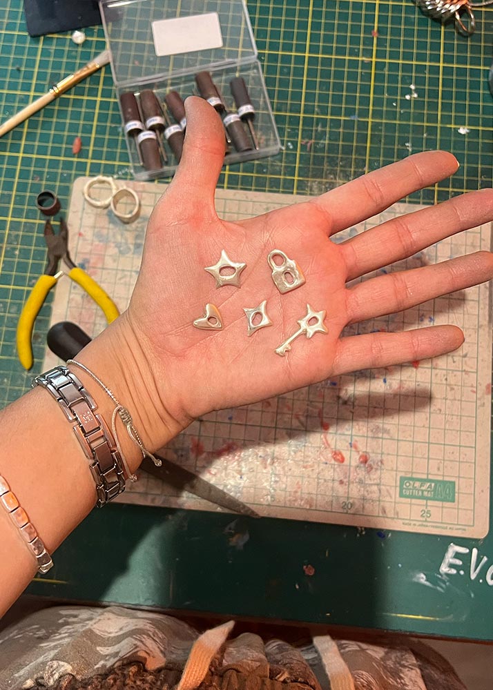 Hand holding small silver charms