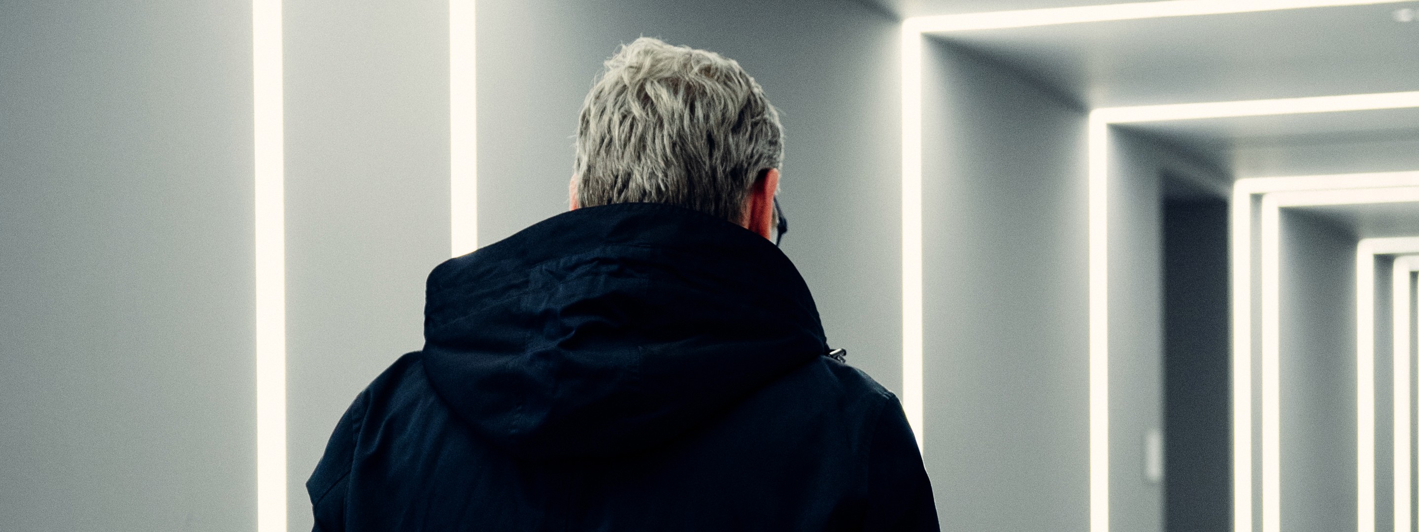 Front view of a car highlighting the grille and headlights in a modern blue-toned setting