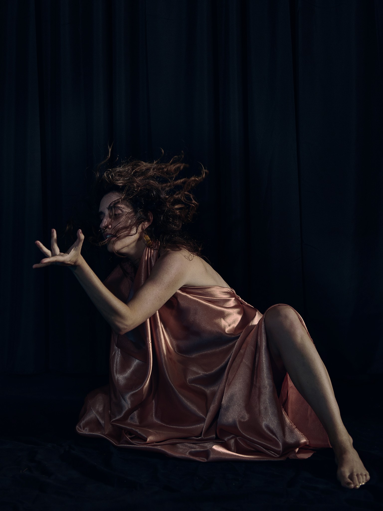 Dancer captured mid performance with artistic and expressive movements against a dark background.
