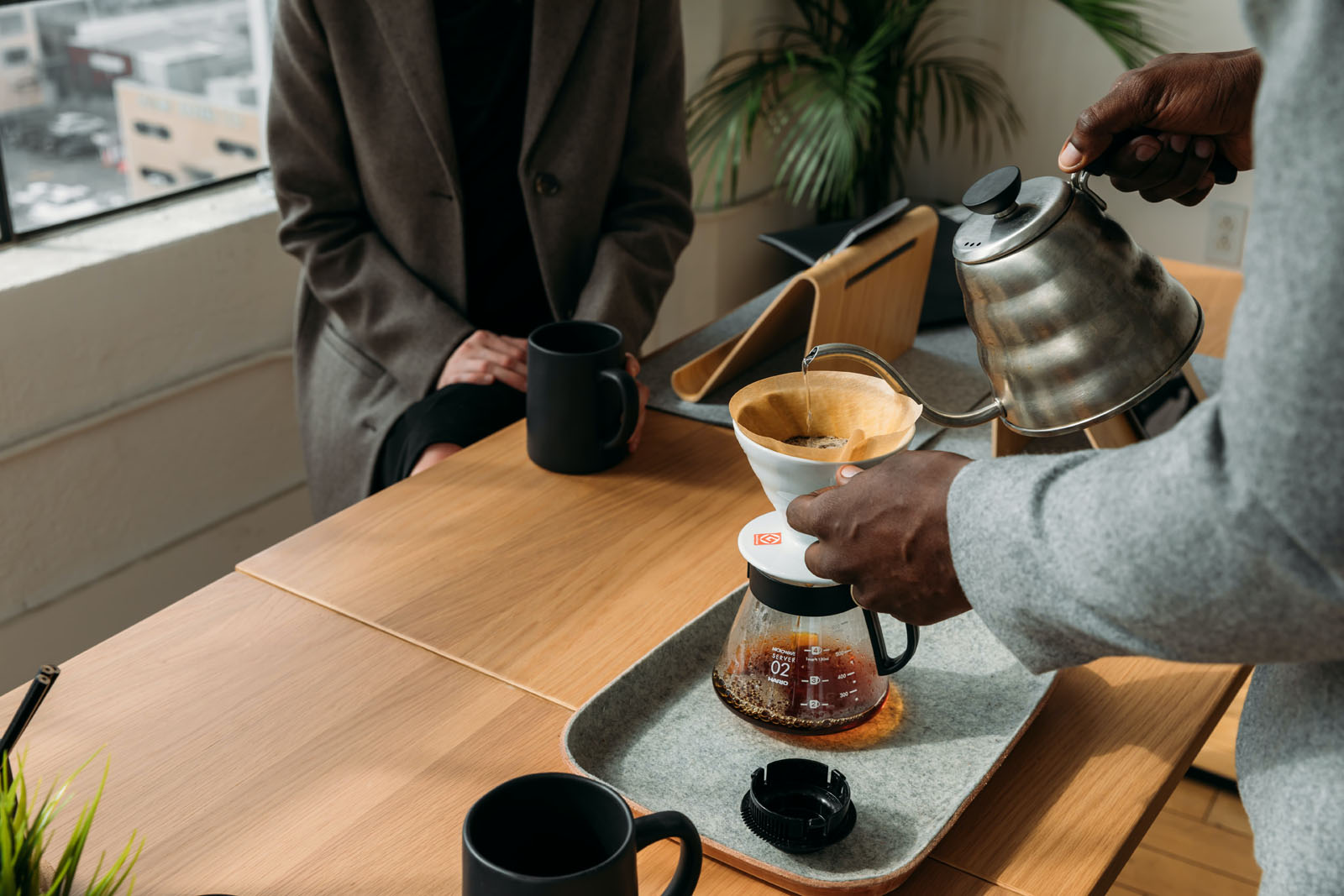 Man making a coffee pour over on wood table