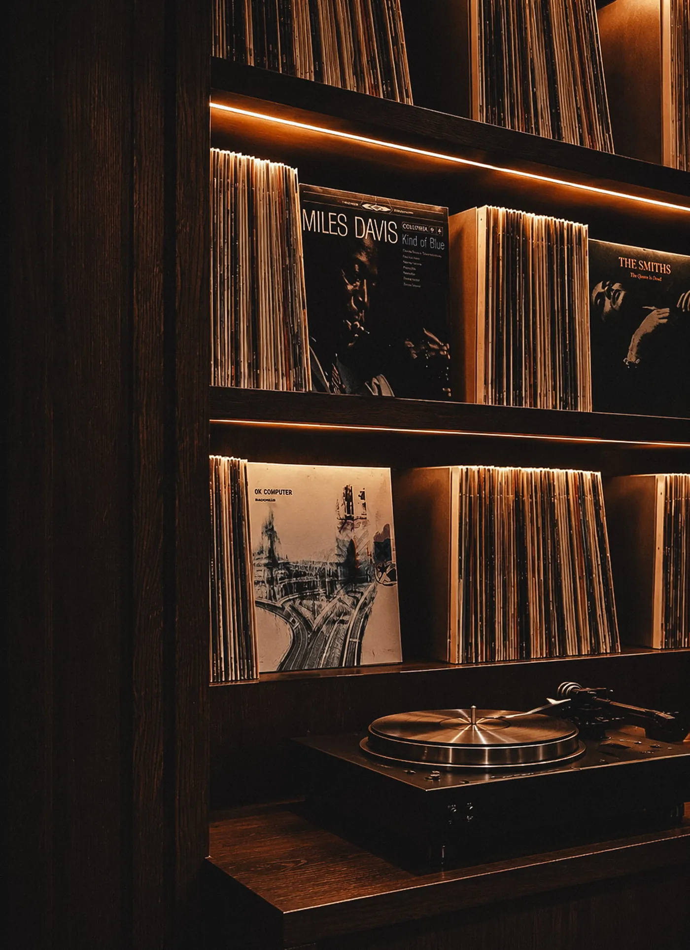 Vinyl records and a turntable on lit shelves in the 14 Clubs clubhouse