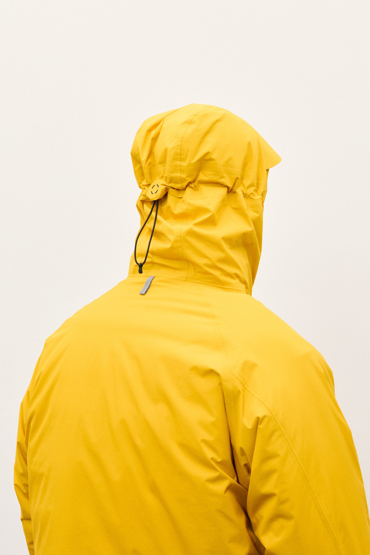 Homme portant une parka technique jaune vif dans le lookbook de Norse Projects