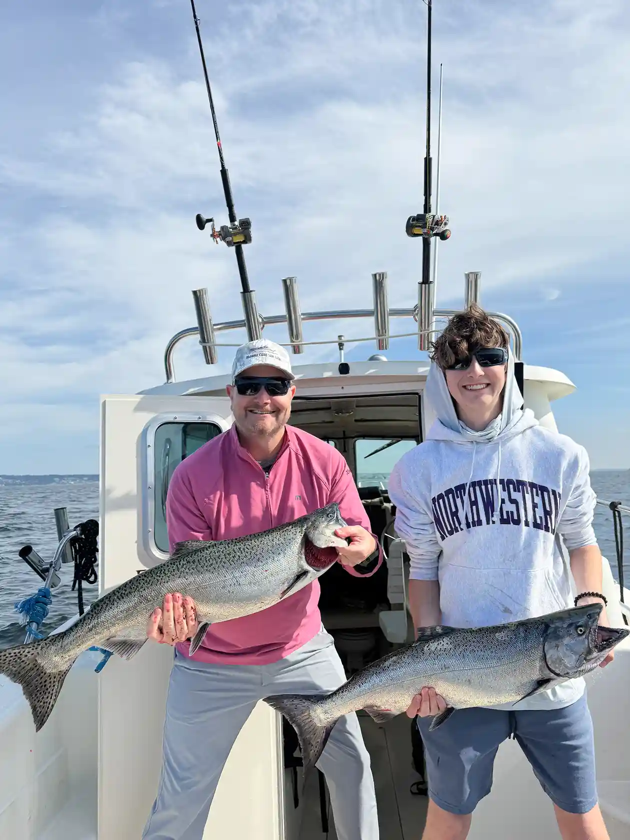 Father and son catching a king salmon at a seattle fishing charter boat