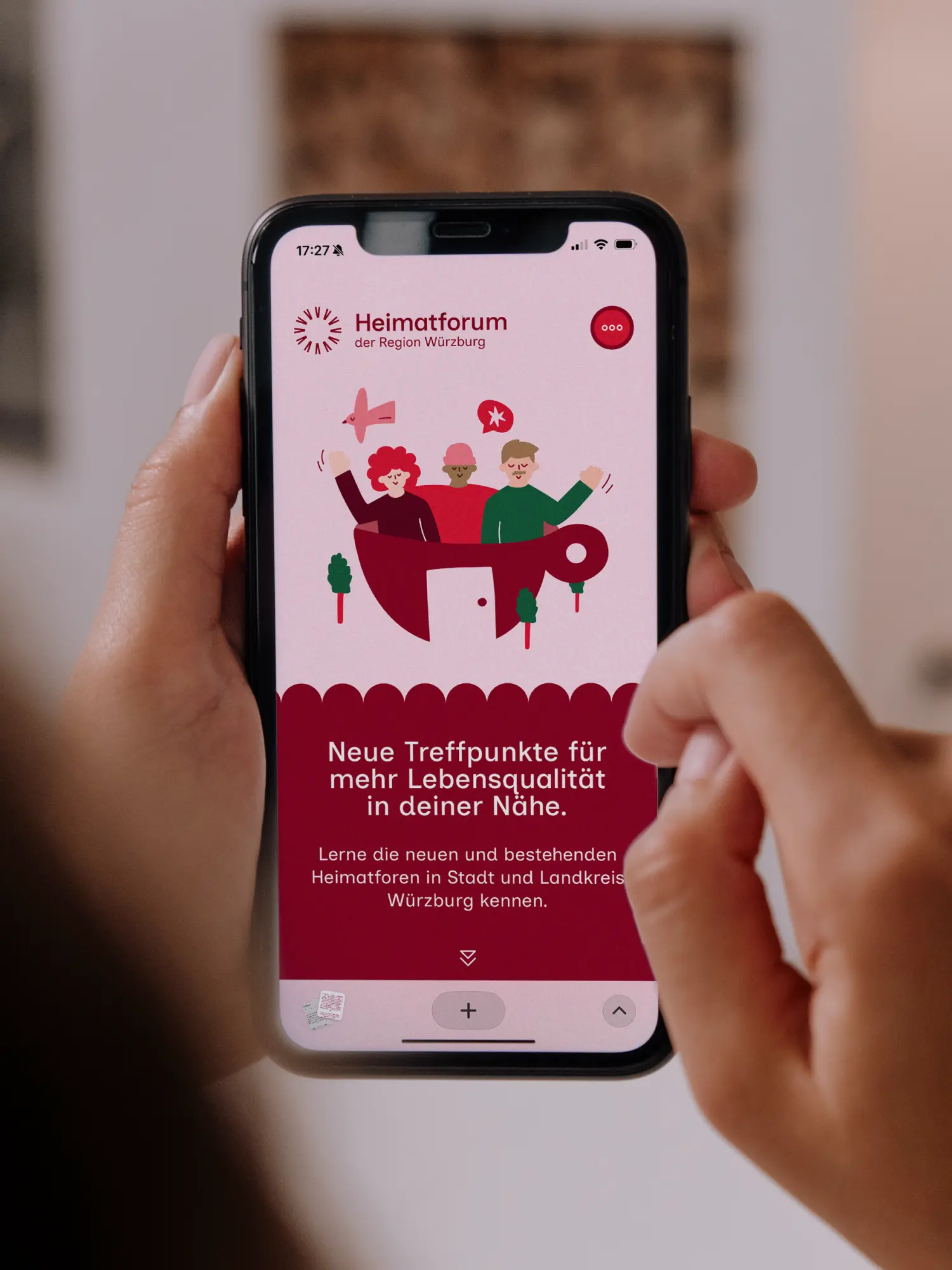 Smartphone zeigt die Heimatforum-Website mit Illustration in einer Kaffeetasse und Headline zu neuen Treffpunkten.