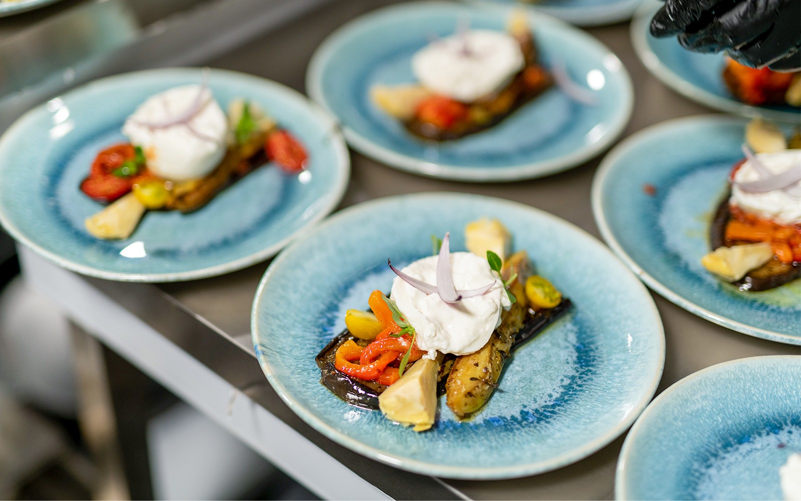 Talijansko predjelo s burratom i pečenim povrćem na plavom tanjuru, pariško krstarenje s večerom.