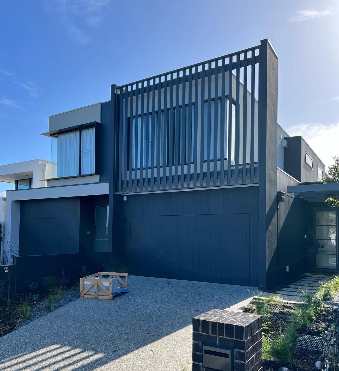 Low angle view of a modern white and orange building under the bright sky