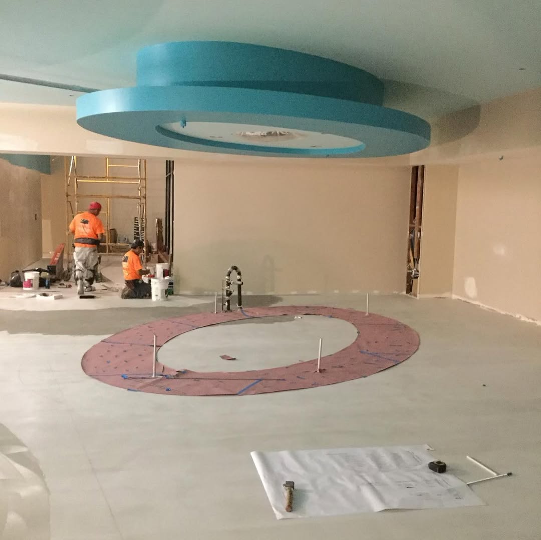 Full-size template struck on a lobby slab to mark a curved vinyl inlay