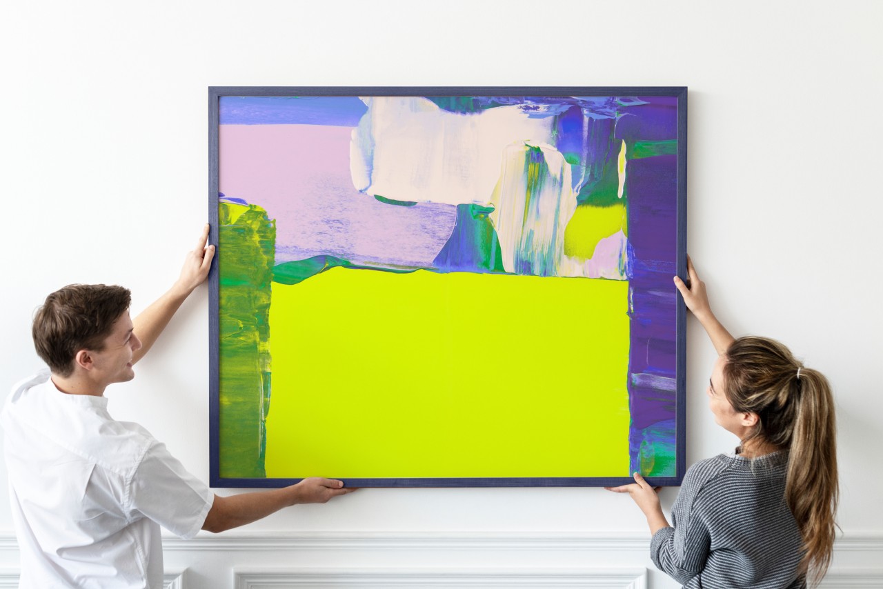 Two people holding a big picture