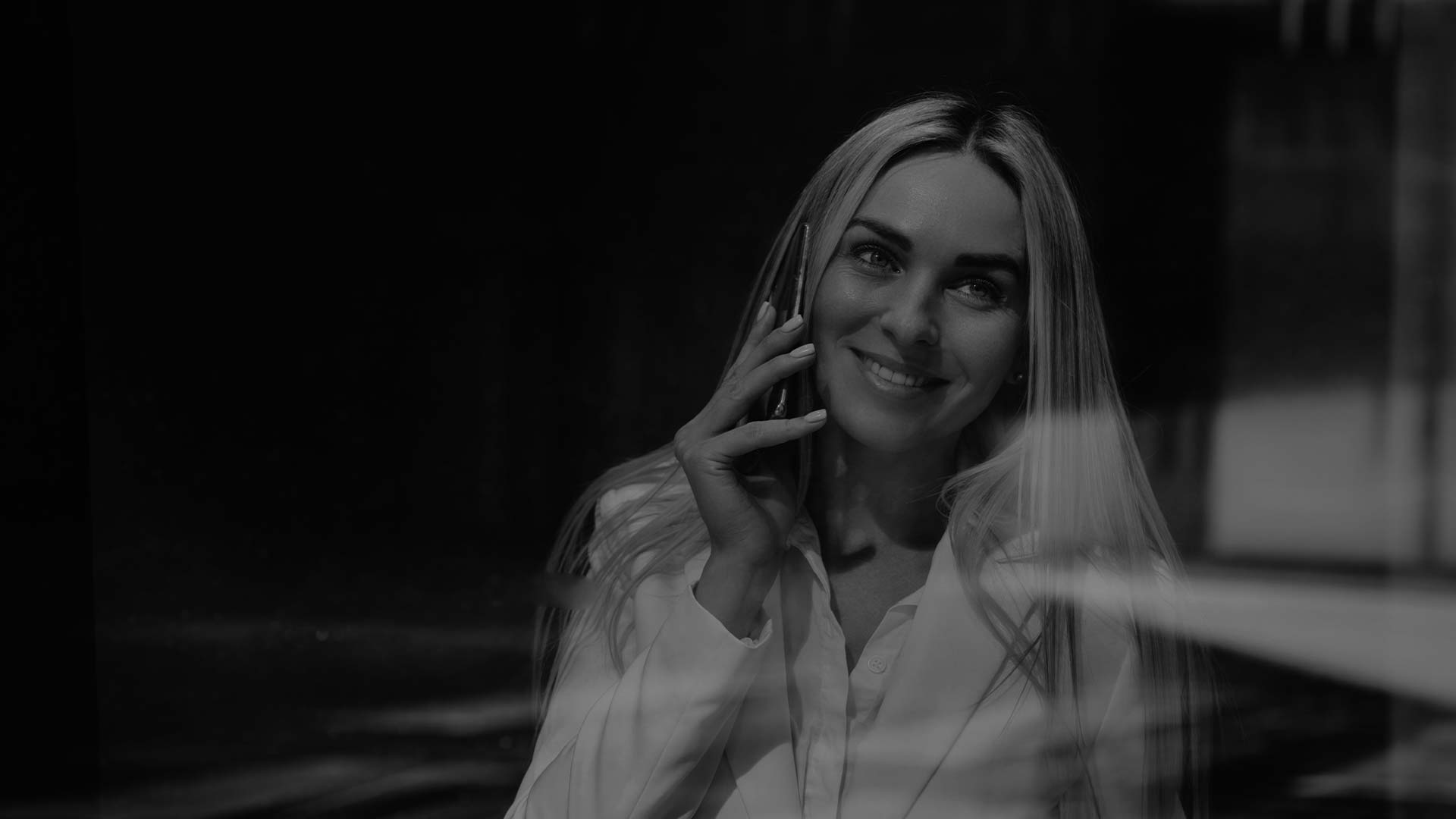 Усміхнена жінка розмовляє по телефону — фон для сторінки контактів компанії