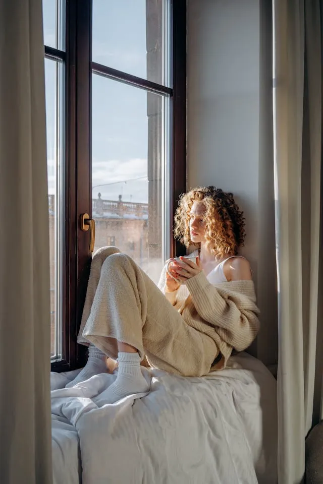 Calm morning scene female looking at the window