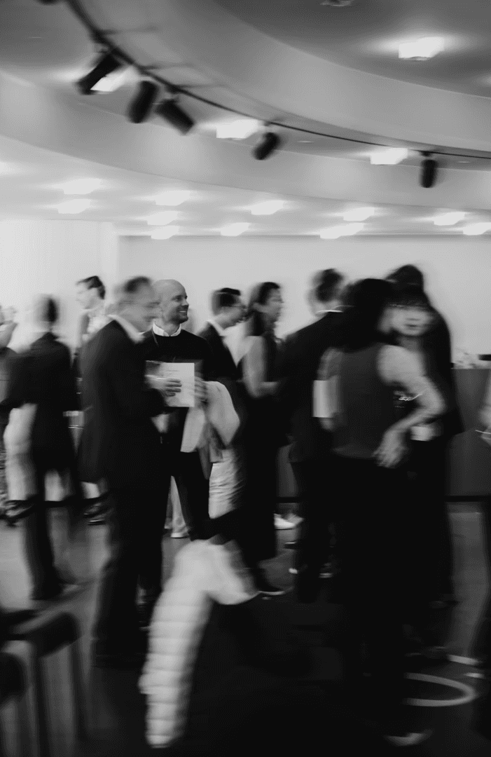 Indoor event with many businesspeople in motion, capturing dynamic movement