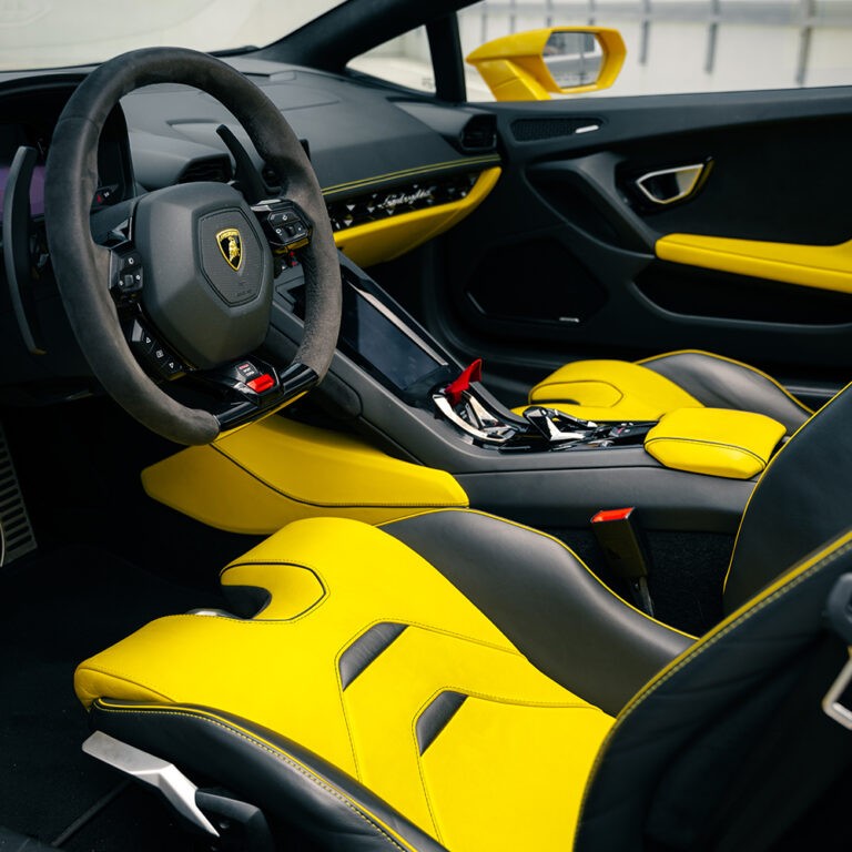 Spacious and stylish interior of the yellow Lamborghini Huracán EVO Spyder, emphasizing the sports seats.