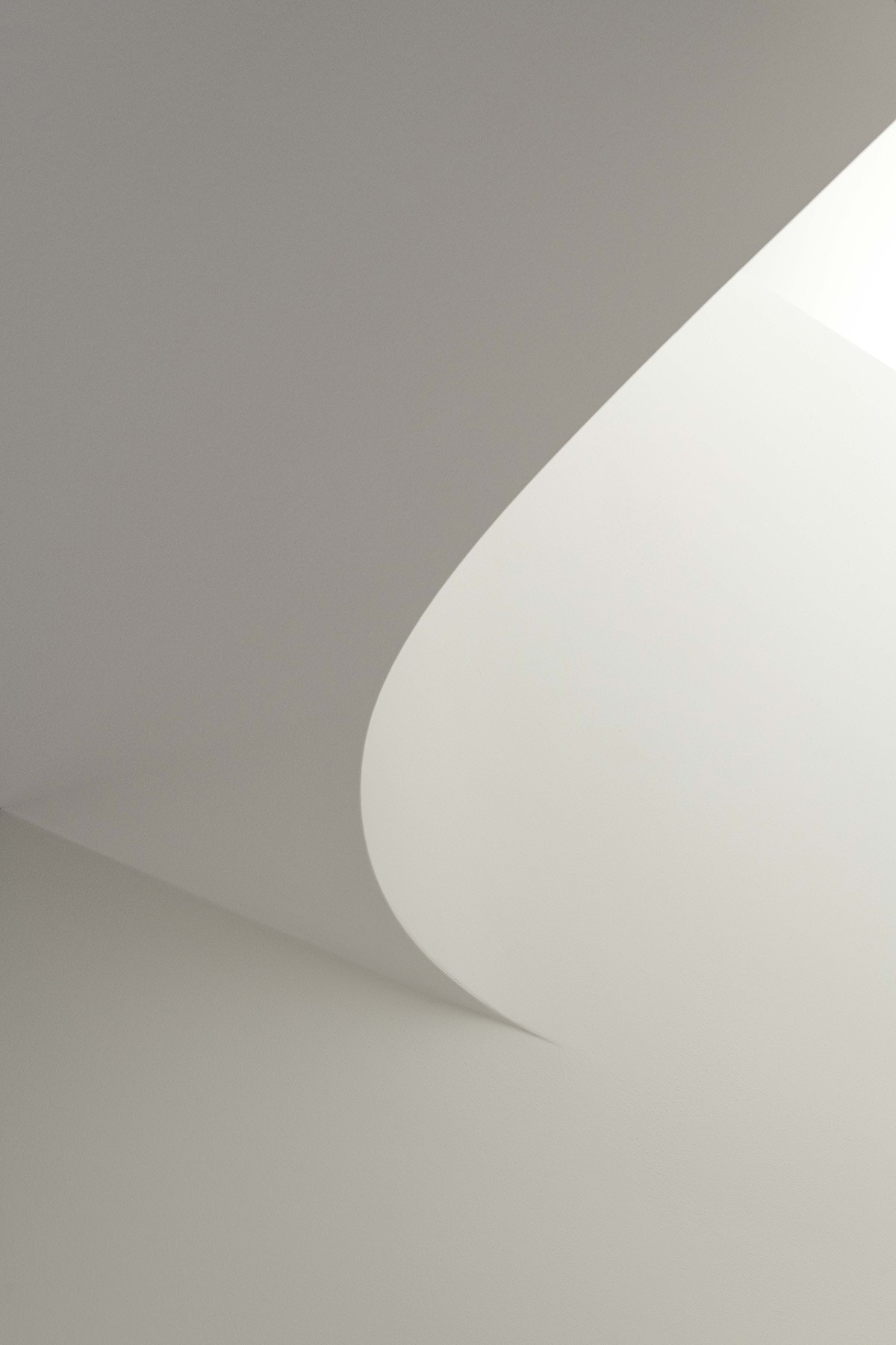 Curved ceiling detail at The Stables, where soft plaster forms shape light and shadow across the interior.