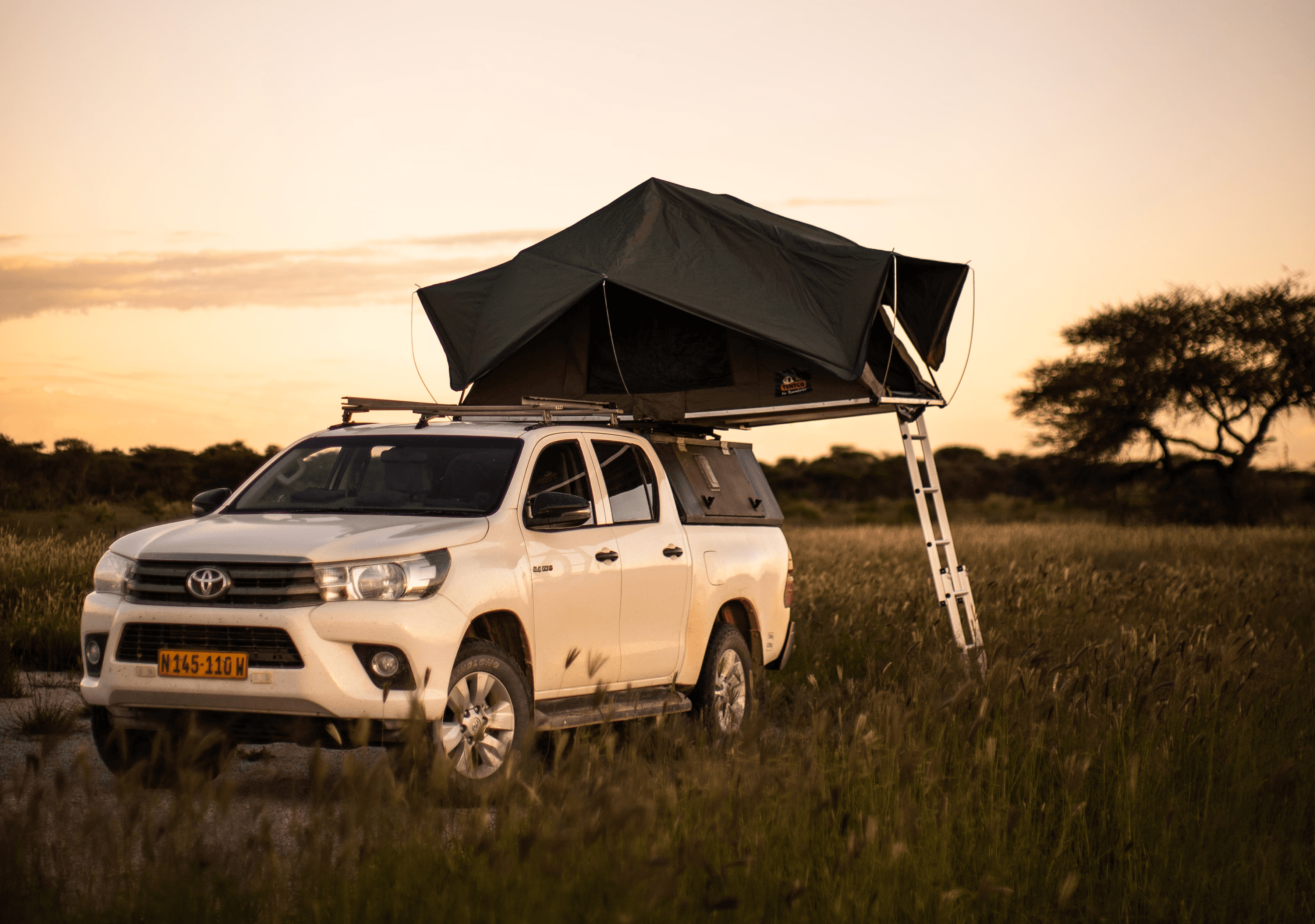 A rooftop tent open in the Namibian savannah.