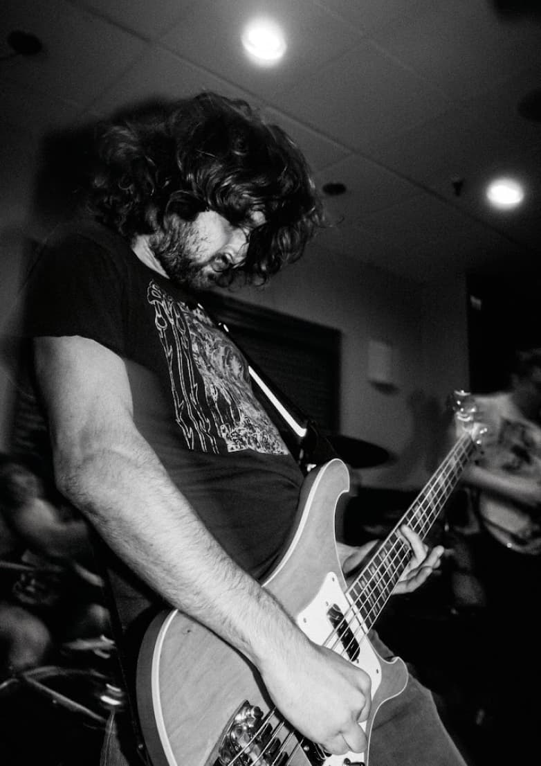 Black and white portrait of CH Moser playing rickenbacker bass at a live show