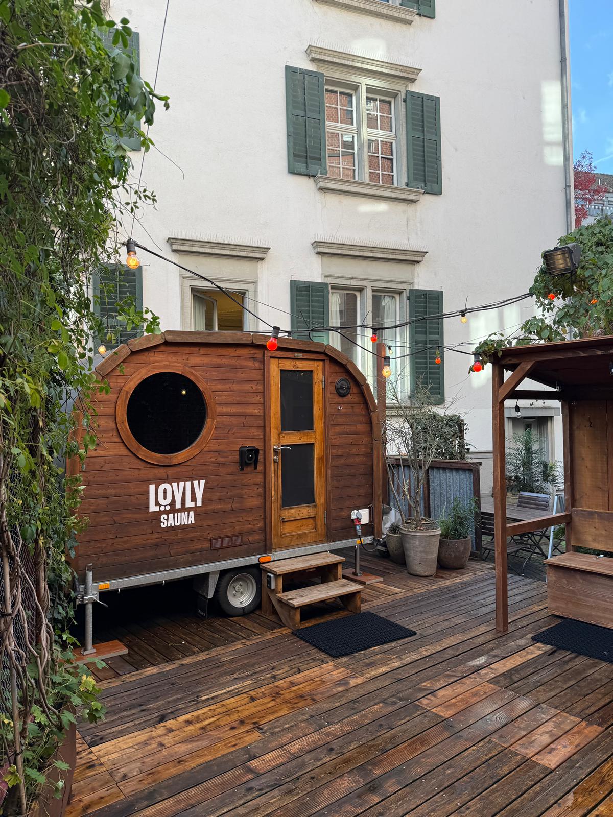 LÖYLY-Sauna am Lago Mio in Weesen, stimmungsvoll am Seeufer mit Liegestühlen und Lichterketten für besondere Wellness-Momente.