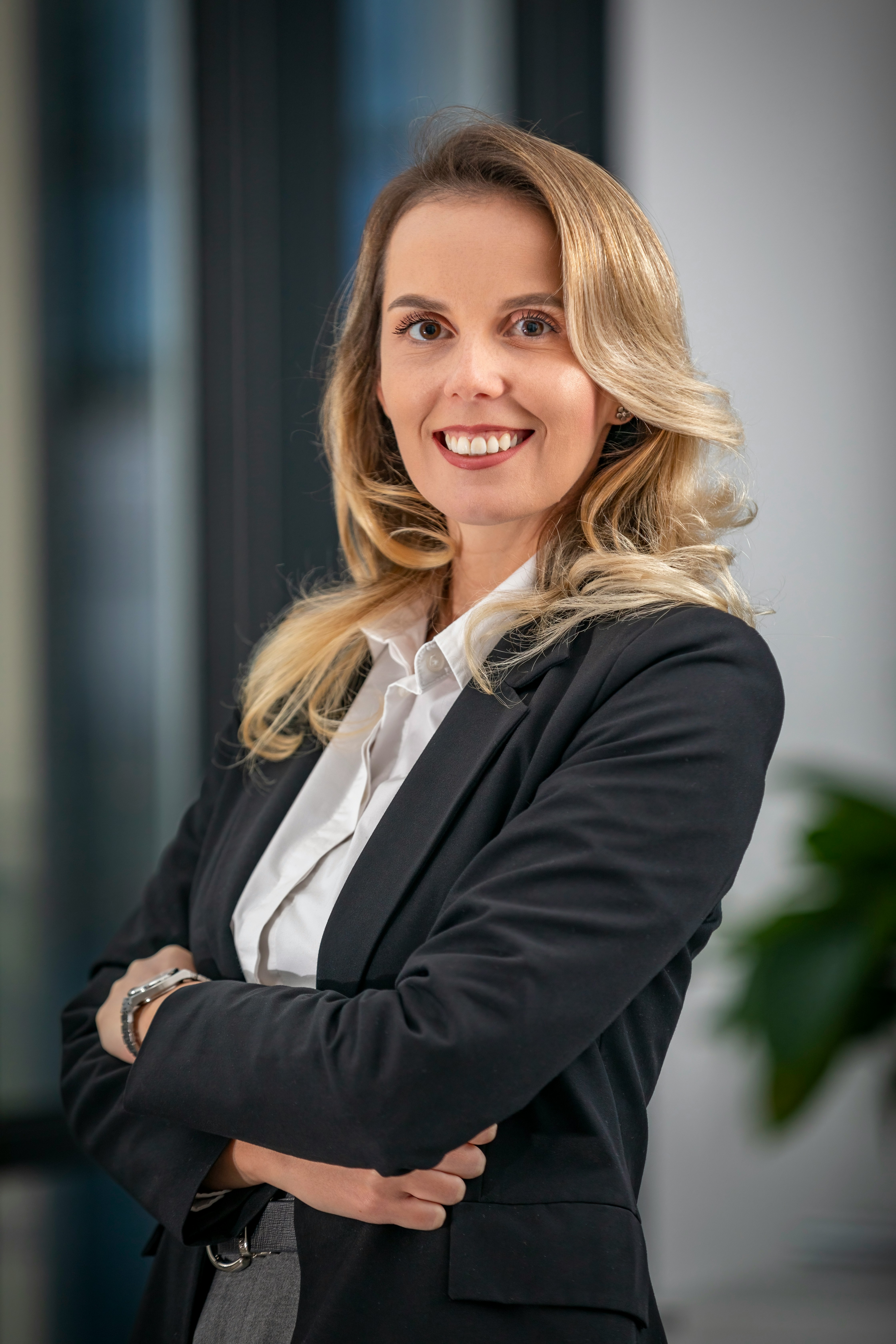 A woman in a business suit standing with her arms crossed