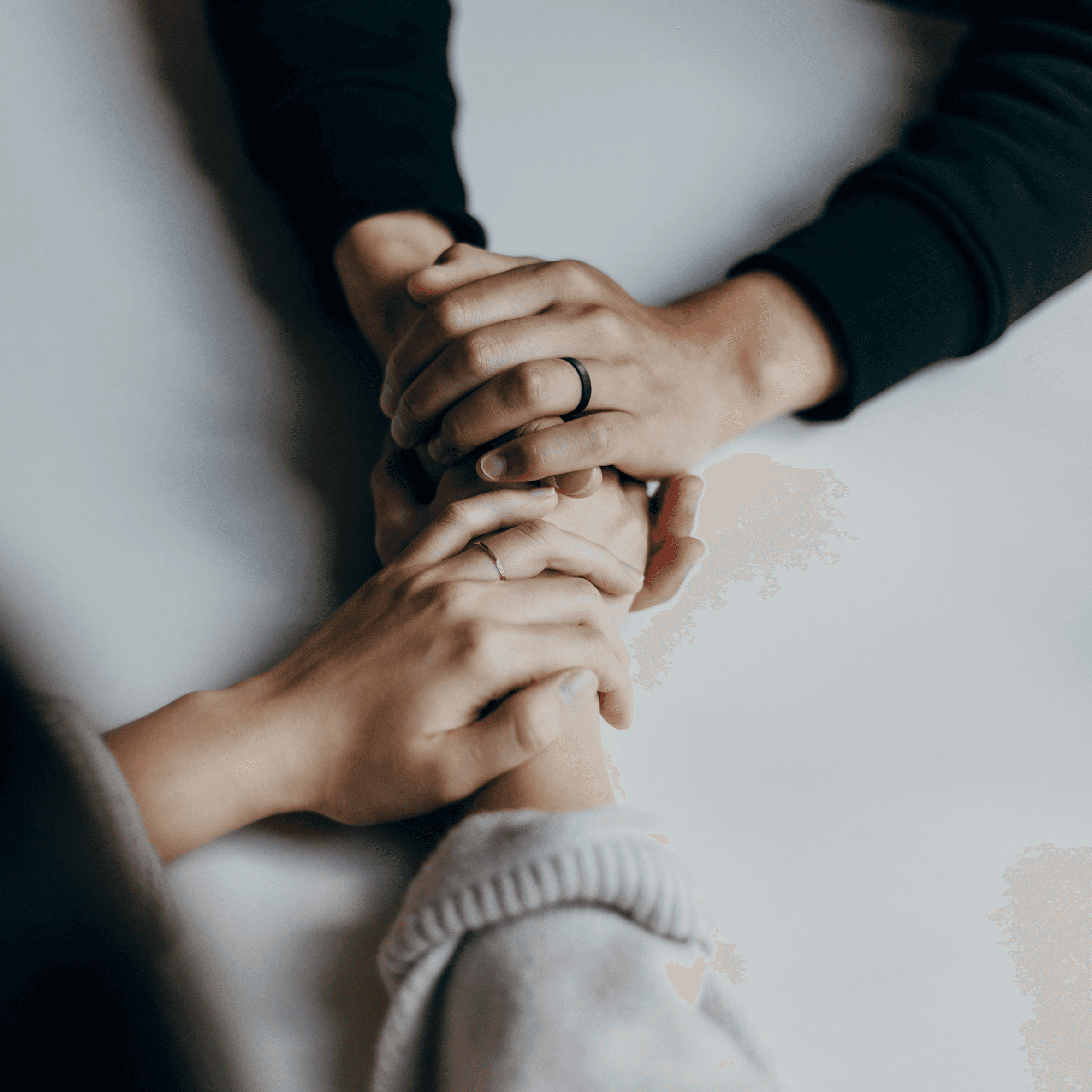 Close-up of a scientist holding a tray of petri dishes with purple cultures, wearing gloves and safety gear.