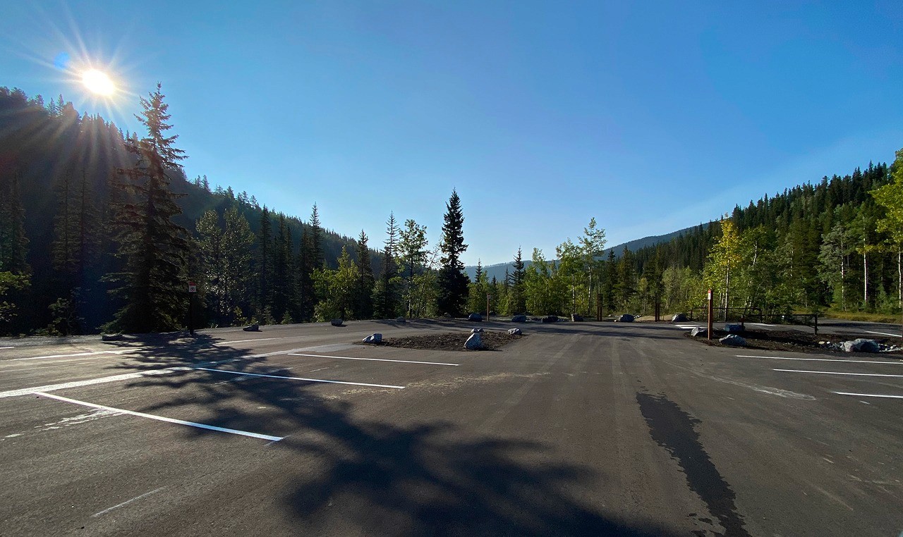 Expanded Moose Mountain trailhead parking lot with native vegetation islands in Kananaskis valley