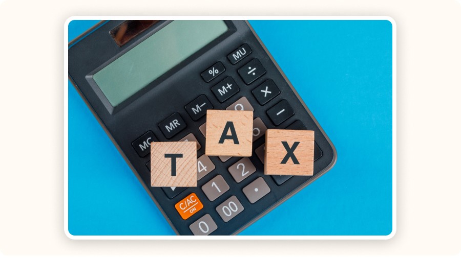 Calculatrice avec lettres en bois formant le mot “TAX”