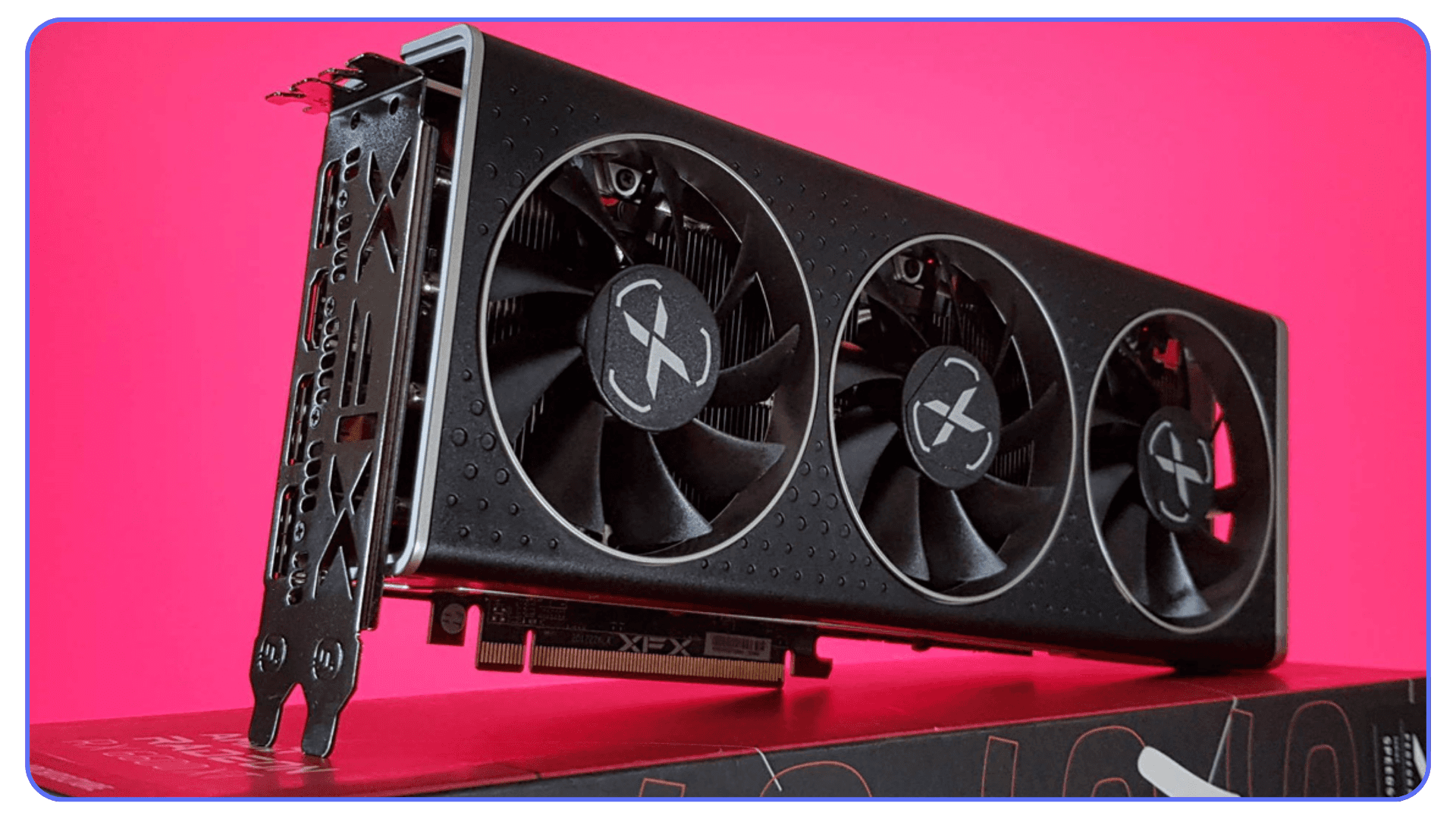 An XFX AMD graphics card with three cooling fans displayed against a bright pink backdrop.