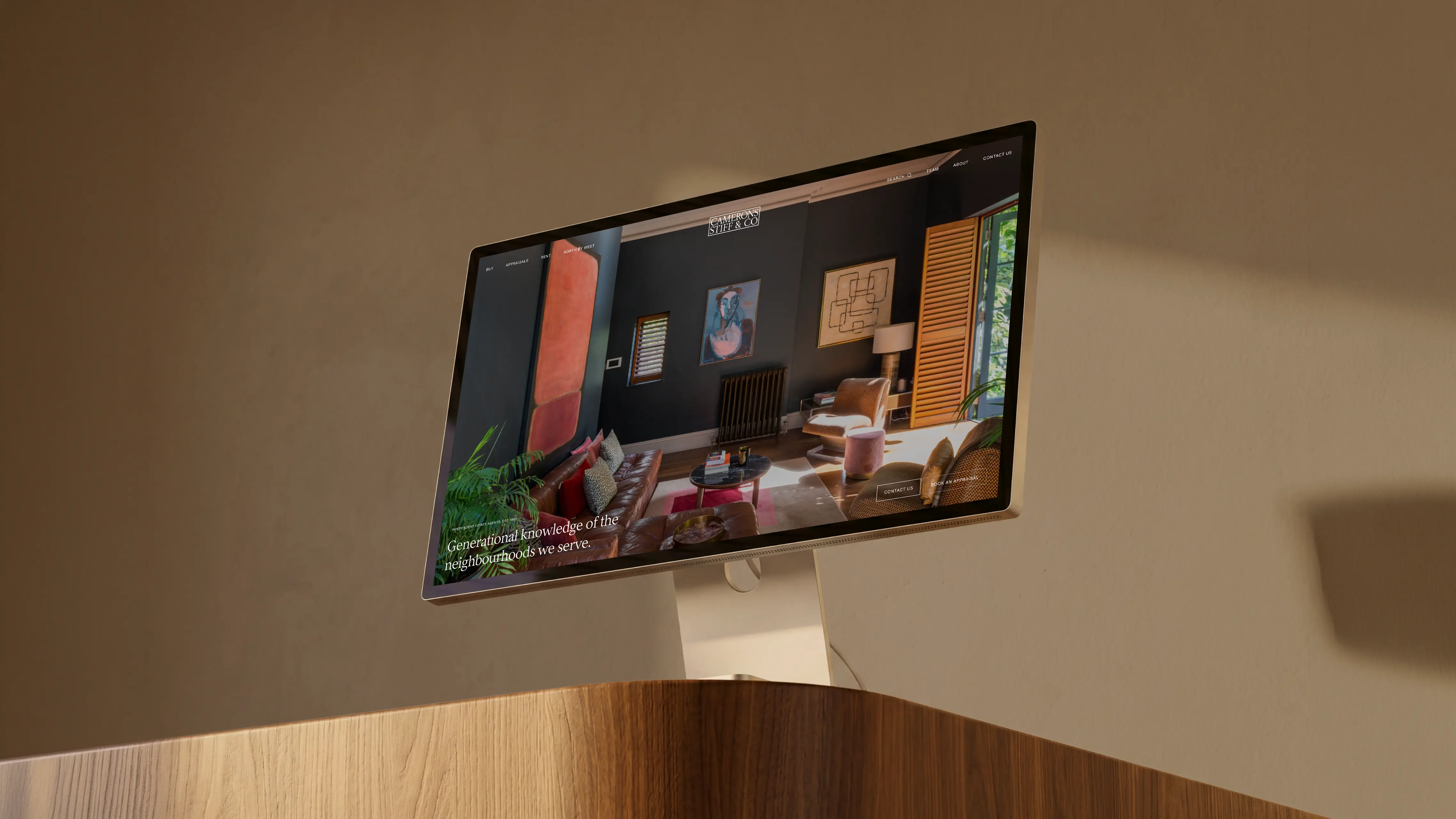 Camerons Stiff & Co website on a desktop monitor, showing a richly styled room