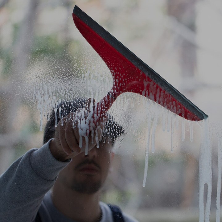 Une raclette rouge qui nettoie une vitre
