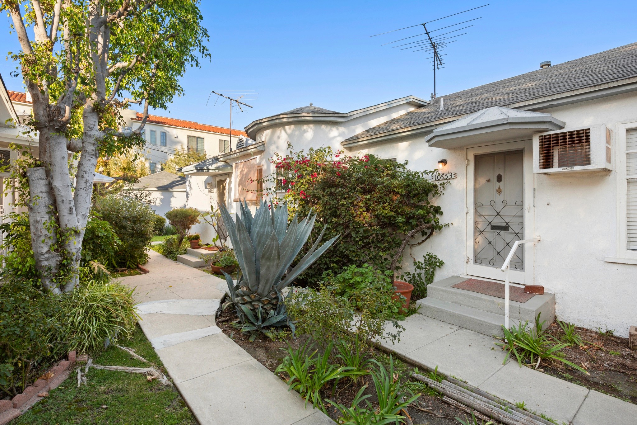 Landscaped courtyard path connecting individual units within the residential triplex at 10651 Whipple.
