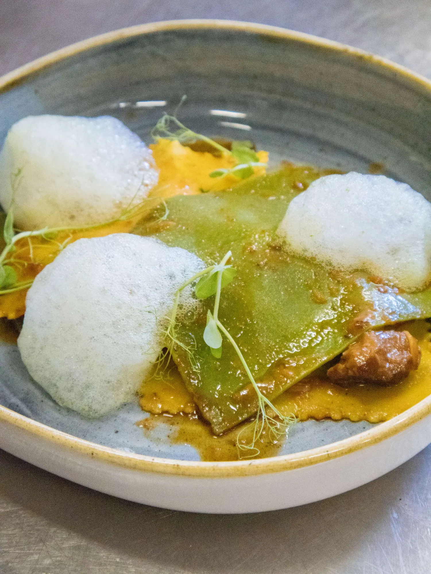 Ravioli artigianali preparati a mano con ingredienti stagionali e impiattamento contemporaneo al Ristorante Unico di Cantù.