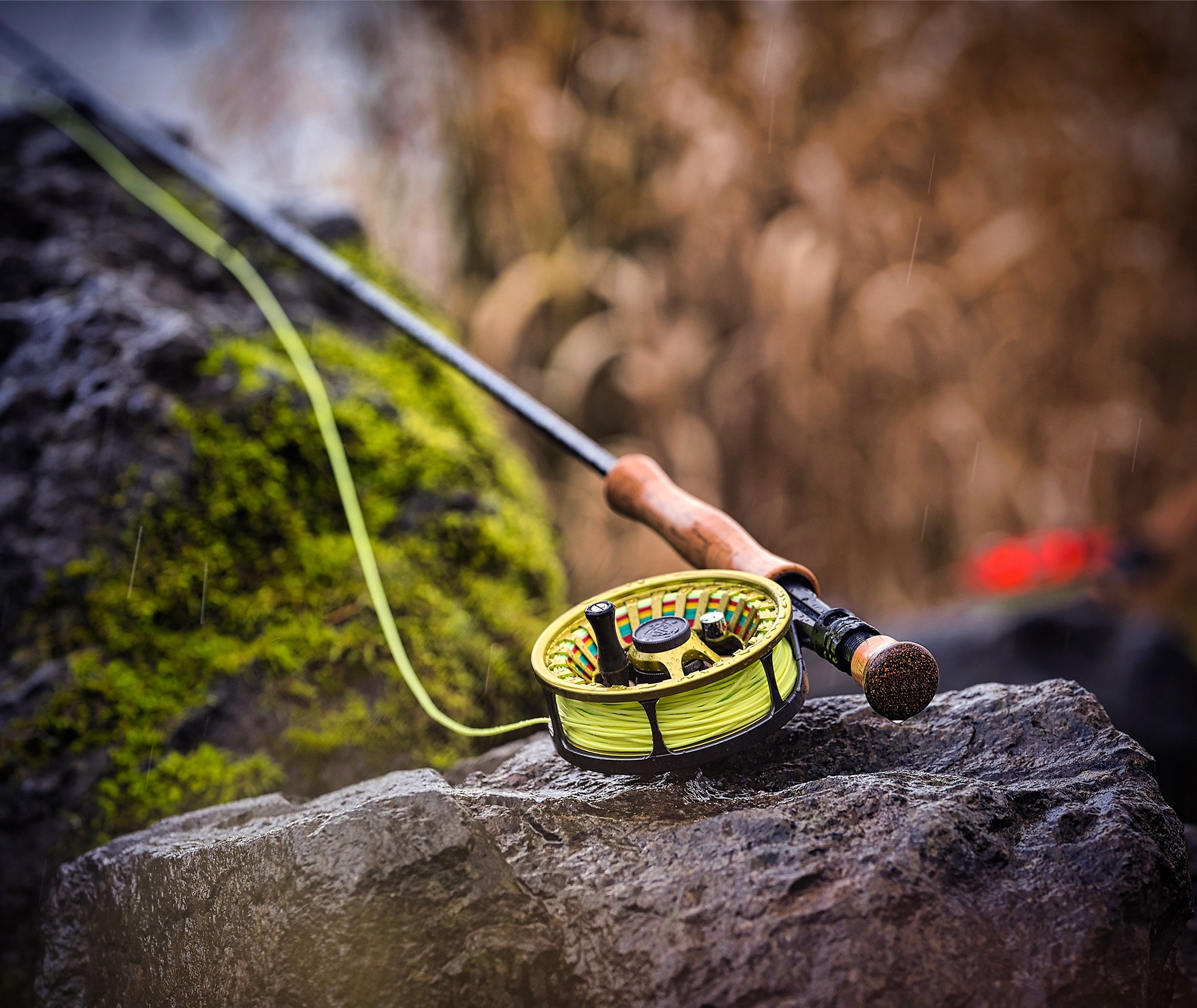 olive fly fishing rod on a rock