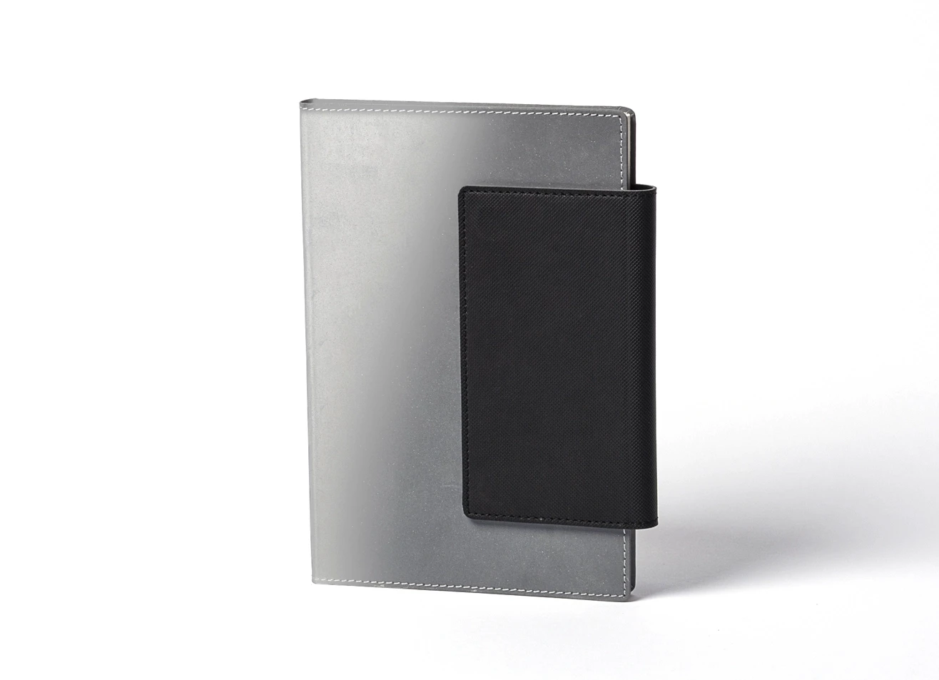 Standing grey notebook with black spine wrap.