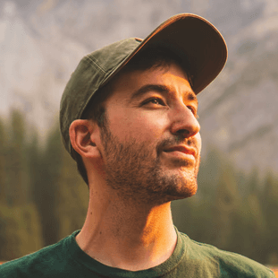 man in green crew neck shirt and black hat
